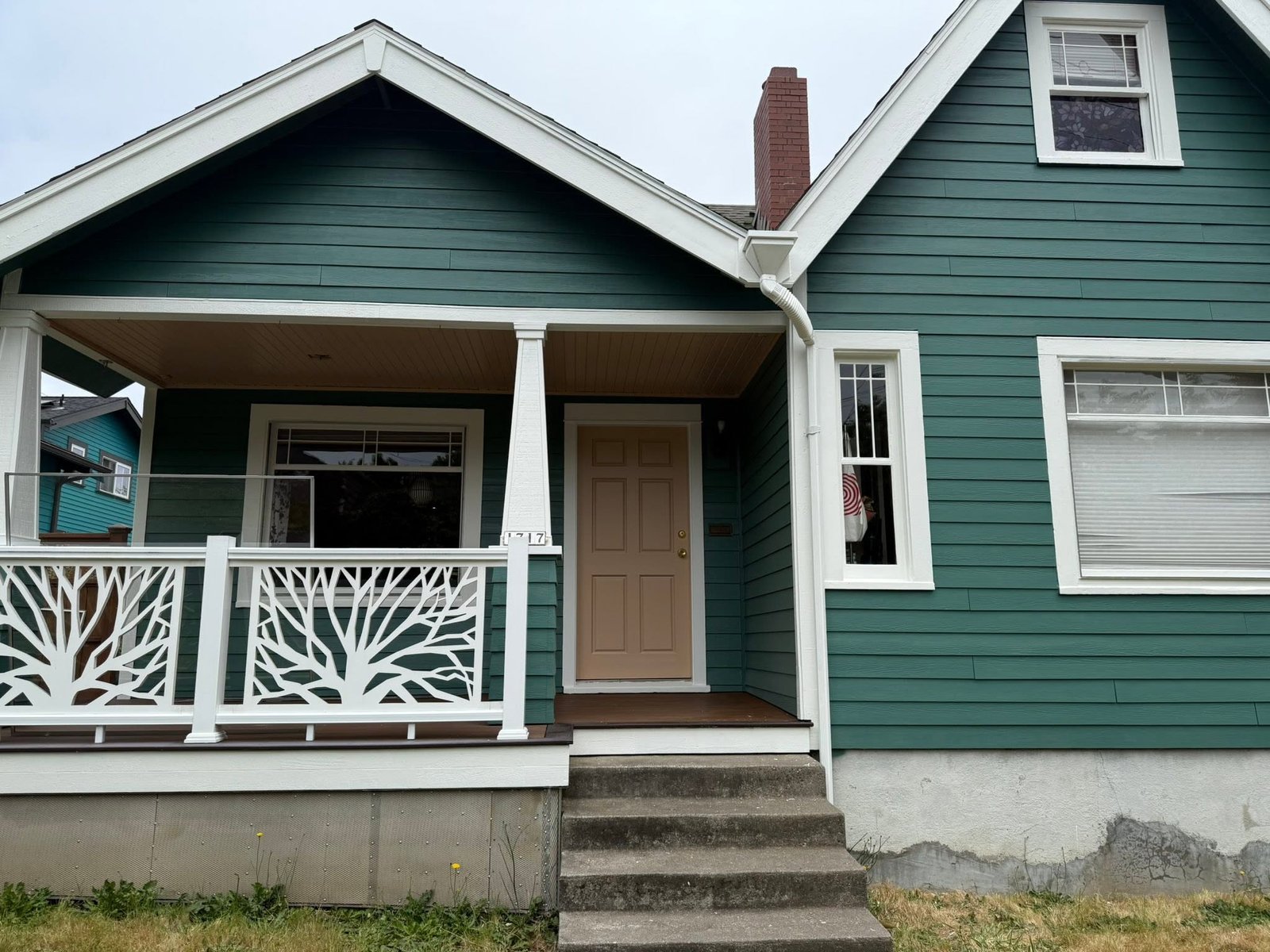 Restored craftsman-style home with a fresh green exterior and white trim
